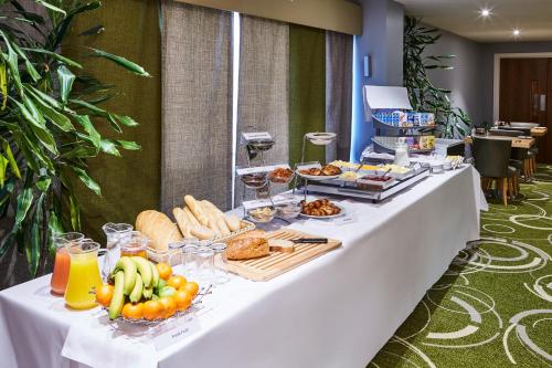 a long white table with food on it at Mercure Newbury West Grange Hotel in Thatcham