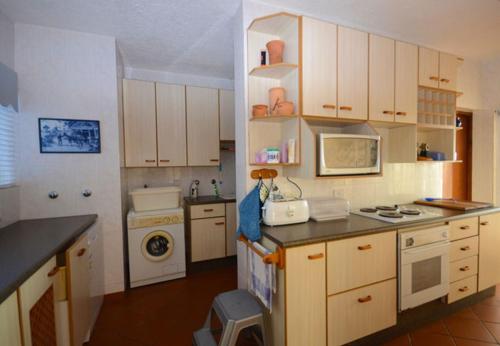 a kitchen with white cabinets and a stove top oven at Nine-ohh Skuitbaai in Eersterivierstrand