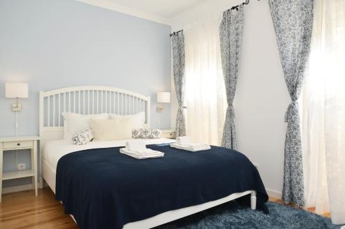 um quarto com uma cama com um cobertor azul em Santana 3 - Checkinhome em Lisboa