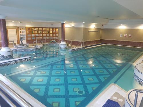 a large swimming pool in a hotel lobby at La Mon Hotel & Country Club in Castlereagh