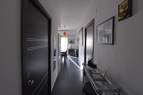 a hallway with a black door and a dining room at Casa sul mare in Isola delle Femmine