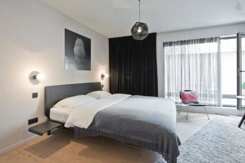 una camera da letto con un letto grande e una grande finestra di B&B Lucy in the Sky ad Anversa