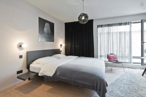 a bedroom with a large bed and a large window at B&B Lucy in the Sky in Antwerp