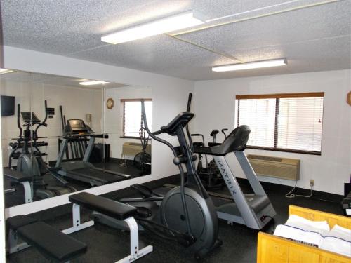a gym with several exercise bikes and a mirror at AmericInn by Wyndham Aberdeen Event Center in Aberdeen