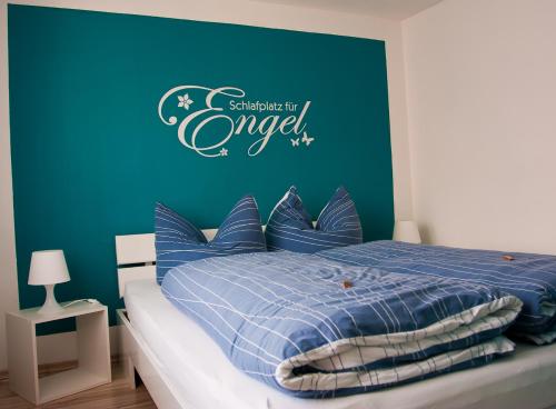 Schlafzimmer mit einem Bett mit blauer Wand in der Unterkunft Ferienwohnung Hornig in Friedrichroda