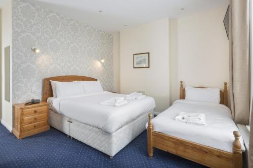 two beds in a hotel room with white sheets at Lobster Hall - Room Only in Whitby