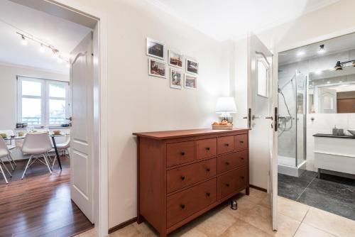 een badkamer met een wastafel en een houten dressoir bij Apartament WILDA in Poznań