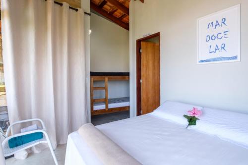 a bedroom with a bed with a flower on it at Haleiwa chalés e suítes - A Guest House do Prumirim in Ubatuba