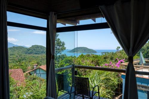 a view from the window of a room with a view of the ocean at Haleiwa chalés e suítes - A Guest House do Prumirim in Ubatuba