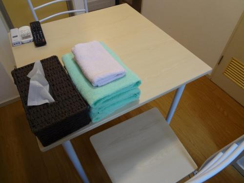 een tafel met drie handdoeken erop bij Guest House ZEN HAKATA Ohori Park in Fukuoka