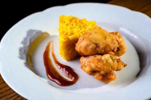 a plate of food with fried food and rice at BS-Ötscher Hotel in Lackenhof