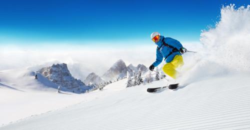 a man is skiing down a snow covered slope at Hotel Gran Baita in Gressoney-Saint-Jean
