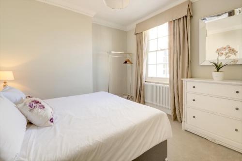 切爾滕納姆的住宿－Wolcote House，白色的卧室设有白色的床和窗户。
