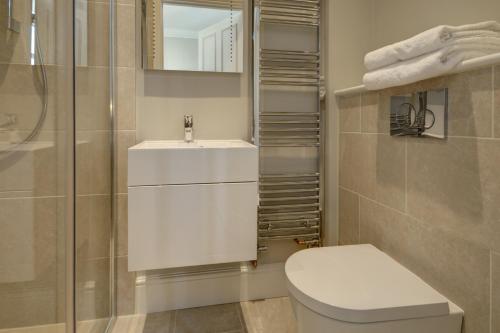 uma casa de banho com um WC, um lavatório e um chuveiro em Wolcote House em Cheltenham