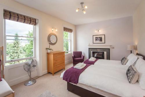 um quarto com uma cama grande e uma lareira em Stunning Spacious Central Apartment near Parade Gardens em Bath