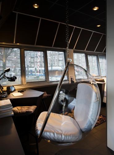 a swing seat in a room with windows at SWEETS - Wiegbrug in Amsterdam