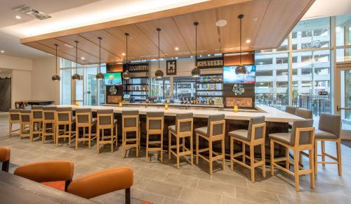 a restaurant with a large bar with chairs and tables at Hyatt House Nashville at Vanderbilt in Nashville