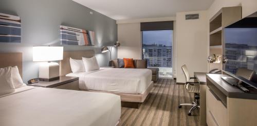a hotel room with two beds and a desk at Hyatt House Nashville at Vanderbilt in Nashville