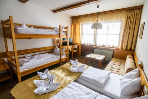 ラッケンホーフにあるBS-Ötscher Hotelの二段ベッド2台とソファが備わる客室です。