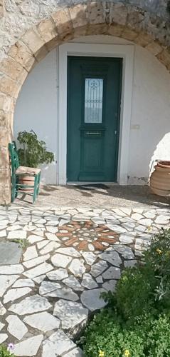 a green door in a building with a stone walkway at Gorgones, sea-front, great view in Kardamili