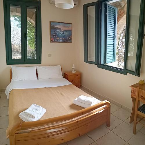 a bedroom with a bed with two towels on it at Gorgones, sea-front, great view in Kardamili
