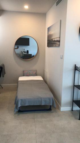 a bedroom with a bed and a round mirror at Different Atmosphere Suite in Caesarea