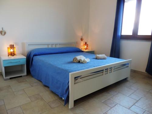 a bedroom with a bed with two towels on it at la casetta rosa in Tertenìa