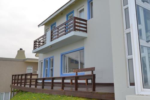 a house with a deck and a balcony at Nine-ohh Skuitbaai in Eersterivierstrand