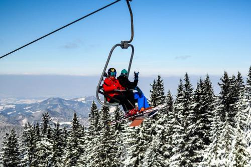 two people riding on a ski lift in the snow at BS-Ötscher Hotel in Lackenhof