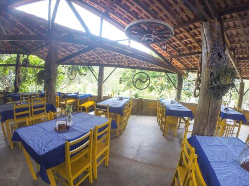 a restaurant with blue tables and yellow chairs at Hotel Fazenda dos Anjos in Cambuquira