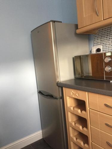 a stainless steel refrigerator in a kitchen at Water side flat in Hawick