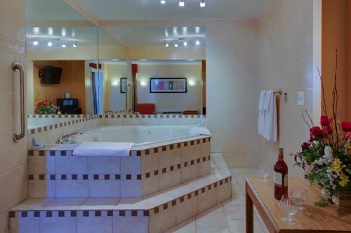 a large bathroom with a tub and a large mirror at Master Suites Hotel in Waldorf