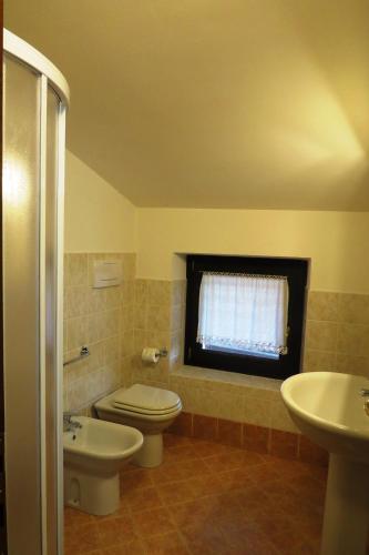 a bathroom with a toilet and a sink and a window at Agriturismo La Staffa in Valeggio sul Mincio