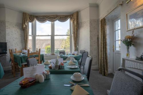 a dining room with a table and a large window at Lyndale Guest House in Ambleside