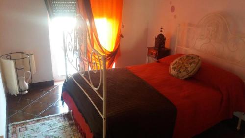 a bedroom with a bed with a red comforter at Évora Romana Alojamentos T3 Cartuxa in Évora