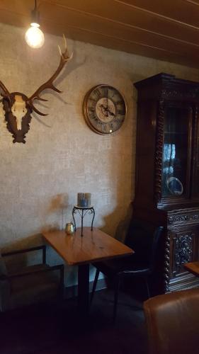 a table and a clock on a wall with a table and a table at Pension Abshoff in Meschede