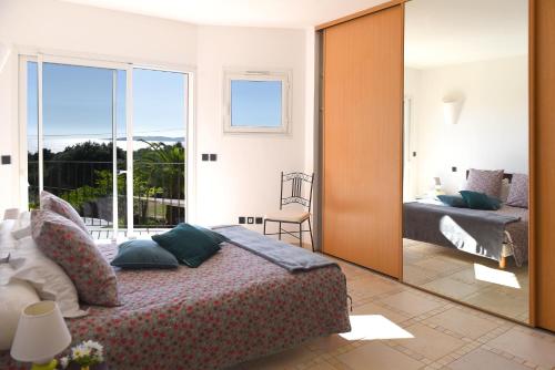 een slaapkamer met een bed en een grote spiegel bij sci marie dominique in Olmeto
