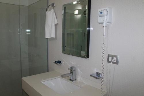 y baño con ducha, lavabo y espejo. en Hotel Davimar, en Guamúchil
