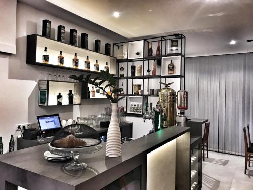 a kitchen with a bar with a vase on a counter at Hotel Bajt Maribor in Maribor