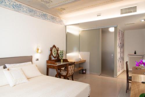 a bedroom with a bed and a desk and a table at Portica10 Assisi in Assisi