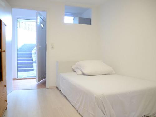 a white bed in a room with a balcony at LMS Apartments in Weiterstadt