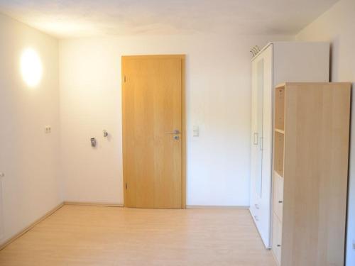 an empty room with a door and a wooden floor at LMS Apartments in Weiterstadt
