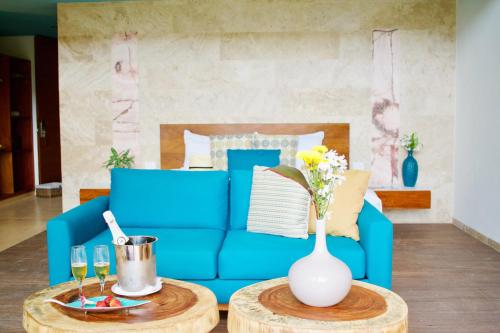 a blue couch and a table with a vase at Villas Caracol in Holbox Island