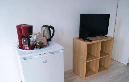 a kitchen with a tv and a coffee maker on a counter at Alex Residence in Otopeni