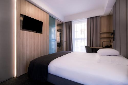 a hotel room with a bed and a television at Bulvar Hotel in Gorzów Wielkopolski