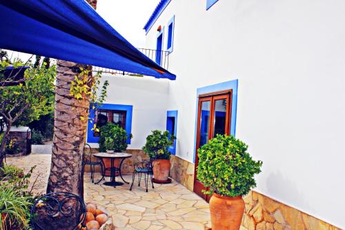 a patio of a house with a table and plants at Agroturismo Can Fuster in Sant Joan de Labritja