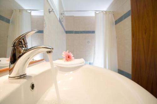 a bathroom sink with a faucet with a pink flower on it at C. Katopodis Mansion in Meganisi