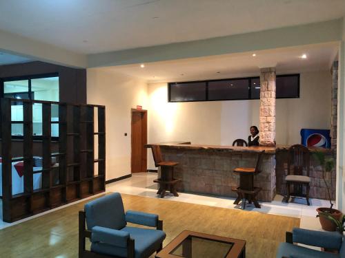 a person sitting at a bar in a living room at Harbe Hotel in Lalībela