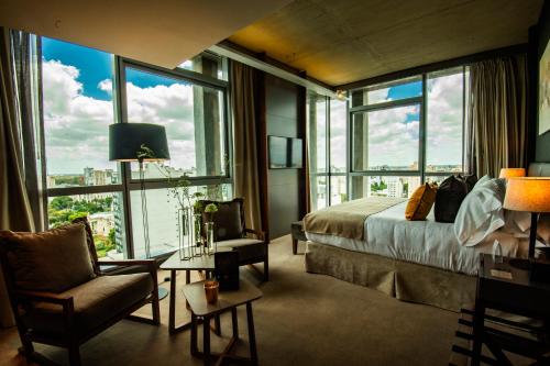 a bedroom with a bed and a large window at Grand Brizo La Plata in La Plata