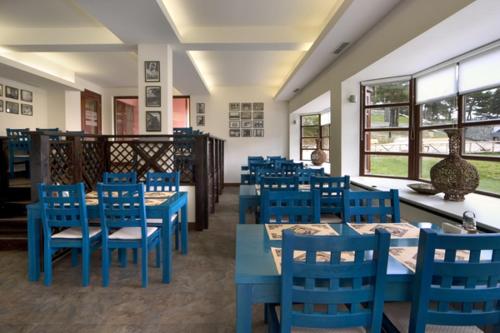 un comedor con mesas azules y sillas azules en Hotel Temenuga en Panichishte